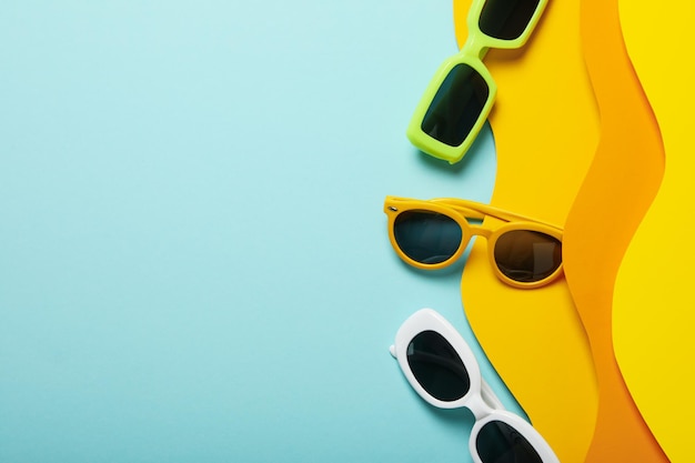 O conceito de óculos na praia em um fundo de papel colorido