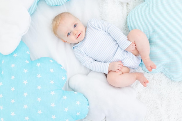 Foto o conceito de páscoa um bebê com um chapéu de coelho em uma cama com ovos de páscua e a inscrição feliz páscoa