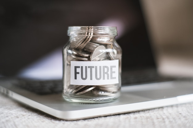O conceito de poupar dinheiro para o futuro - um frasco de vidro com moedas.