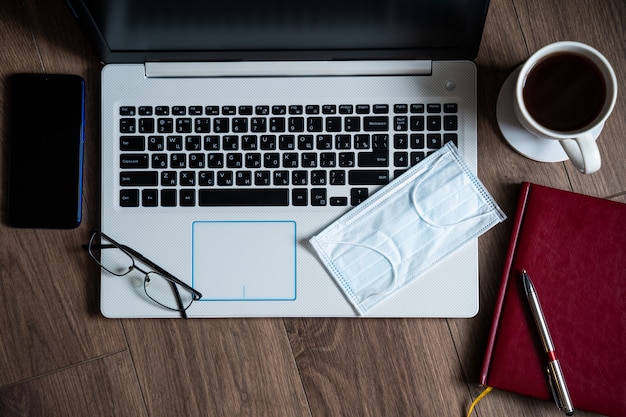 O conceito de trabalho remoto durante uma epidemia. laptop em cima da mesa, produtos de higiene