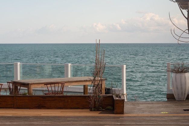 O conceito de um descanso medido à beira-mar O lugar perfeito para um encontro Restaurante com móveis de madeira lanternas árvores à beira-mar