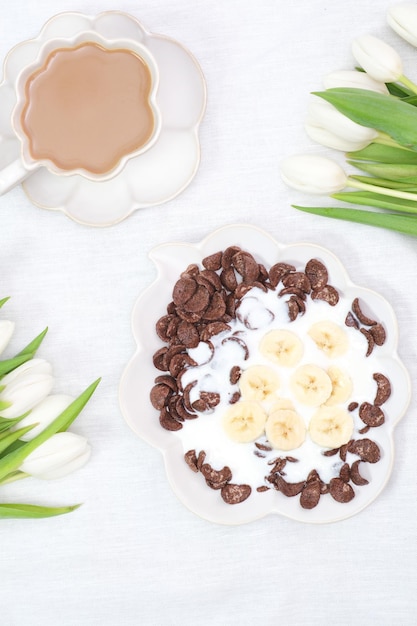 O conceito de um pequeno-almoço saudável de iogurte vegetariano cornflock e flores de café de frutas frescas