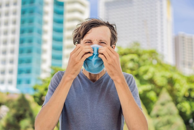 Foto o conceito de uso impróprio da máscara o homem que coça o nariz debaixo da máscara toca a máscara