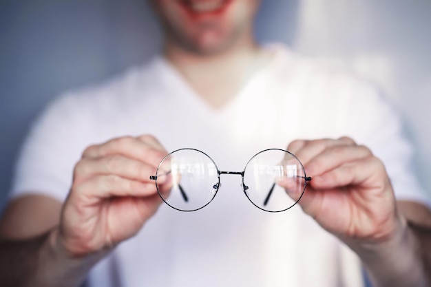 O conceito de visão deficiente. Segure uma lente de contato e óculos. Um cartaz para publicidade de óculos e lentes.