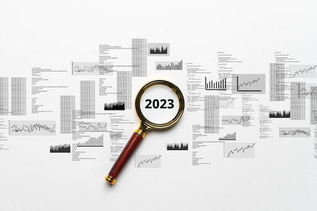O conceito do novo ano 2023 Lupa com gráficos e números abstratos como análise