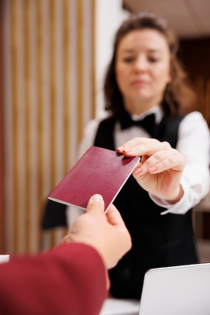O concierge do hotel verifica o passaporte.