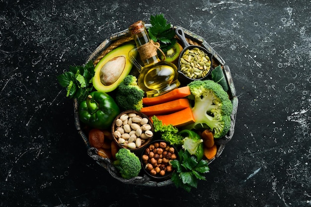 O conjunto de alimentos ricos em vitamina e abóbora brócolis damascos secos salsa abacate e legumes vista superior estilo rústico