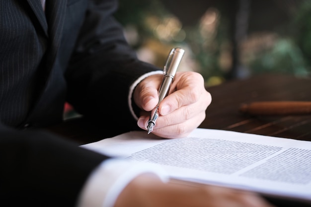 Foto o consultor jurídico apresenta ao cliente um contrato assinado com martelo e leis legais. conceito de justiça e advogado.