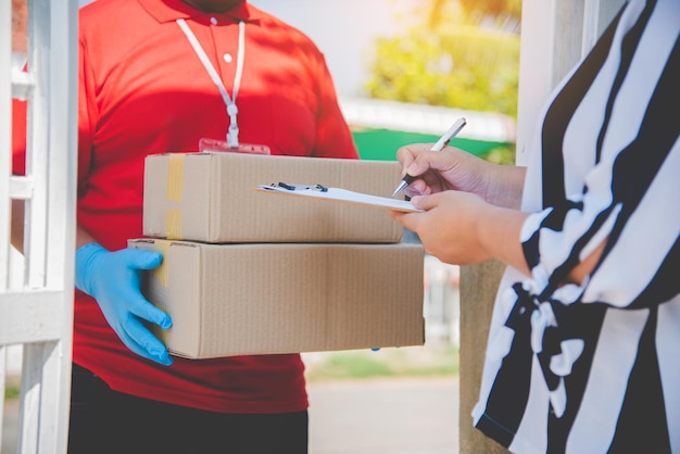 O consumidor está assinando um documento para receber um pacote de um mensageiro doméstico.