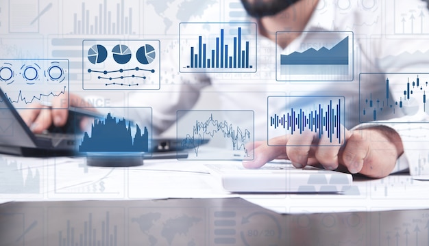 O contador analisa gráficos de relatórios de negócios e gráficos financeiros. Finança. Economia. Bancário. Mercado de ações