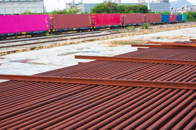 O contêiner frontal no trem e na ferrovia está aguardando enviado para o porto esta imagem para o conceito logístico de importação e exportação cena do tanque da refinaria de petróleo e coluna da torre da indústria petroquímica