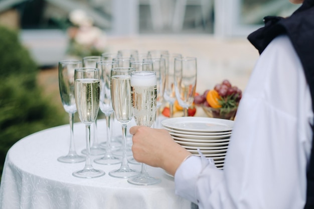 O convidado pega uma taça de champanhe da mesa do bufê durante um feriado ou festa