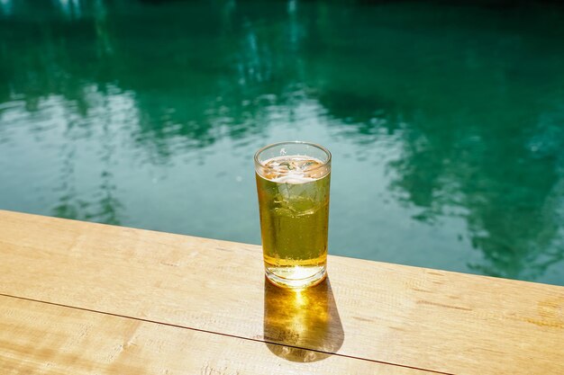 O copo de cerveja sobre a mesa no fundo do mar Bolhas de cerveja tailandesa cheias de gelo