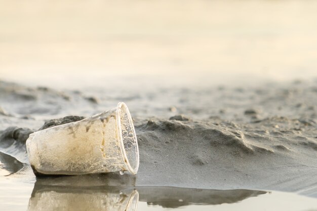 O copo plástico dos desperdícios deixado na praia faz a poluição