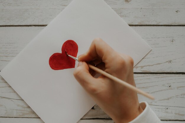 O coração vermelho é pintado em papel branco.