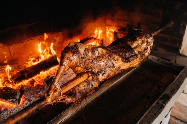 O cordeiro é cozido inteiramente no espeto no fogo Cozinhar