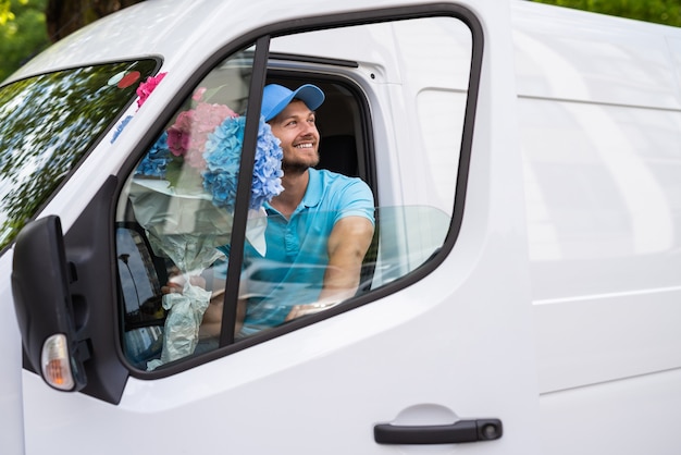 O correio dentro da van branca durante a entrega das flores está esperando