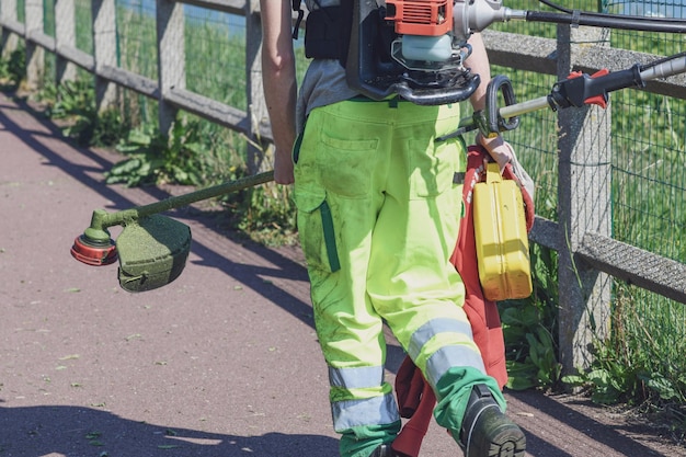 O cortador de grama com equipamento vai trabalhar