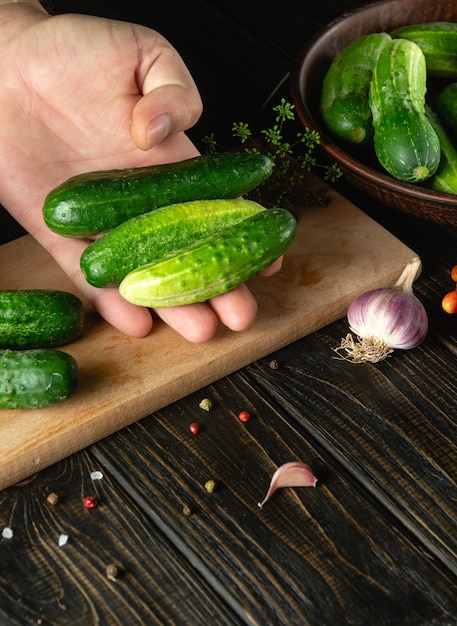 O cozinheiro classifica pepinos antes de enlatar em uma jarra