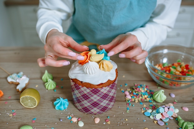 O cozinheiro da cozinha da casa coloca figuras doces na cereja do bolo de Páscoa