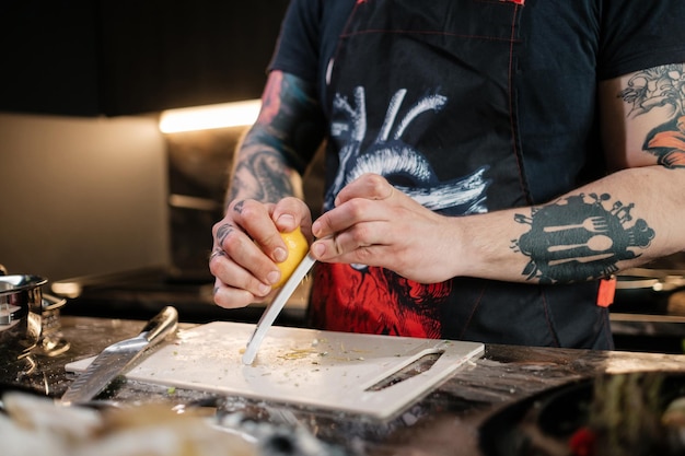 O cozinheiro descasca as raspas de limão O conceito de fazer molho suculento