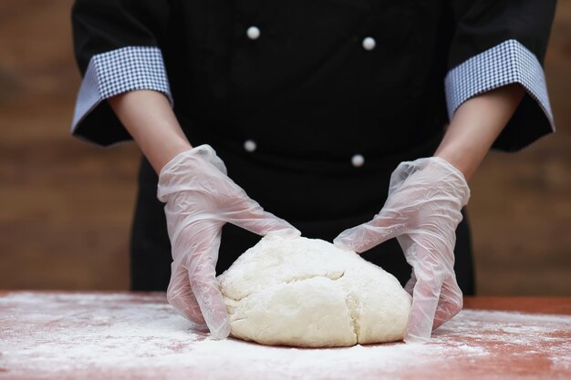 o cozinheiro faz farinha de farinha para assar em cima da mesa