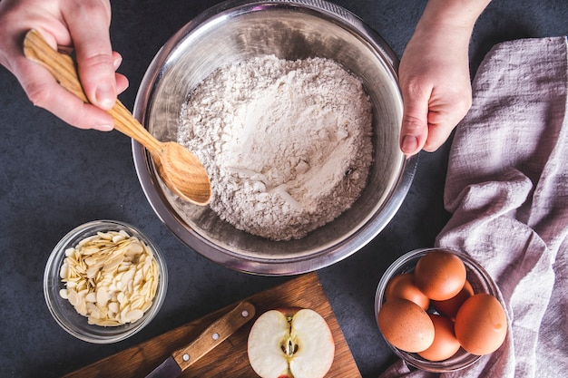 O cozinheiro mistura ingredientes para torta de maçã. Ingredientes para assar torta fresca. Vista do topo.