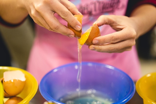 O cozinheiro quebra o ovo na cozinha preparando uma deliciosa refeição