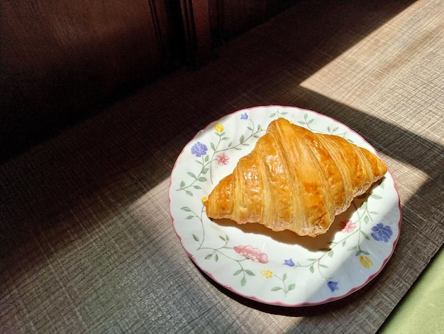 O croissant está em uma placa cerâmica