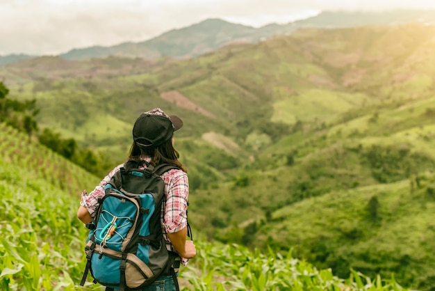 O curso asiático da trouxa da jovem mulher aprecia com fundo do céu na exploração agrícola do arroz da natureza.