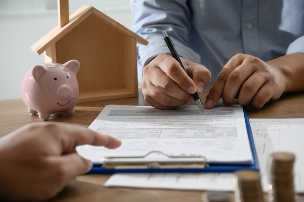 O da casa própria Pessoas de negócios negociando um contrato Aqui é onde você precisa assinar