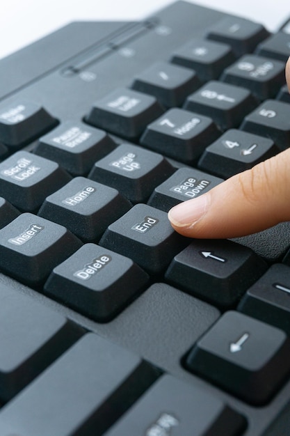 O dedo de uma mulher segurando um teclado de computador