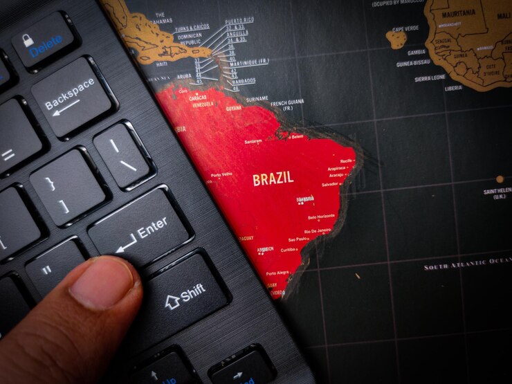 Foto o dedo está pressionando enter no teclado preto que está acima do mapa do brasil negócios e conceitos políticos