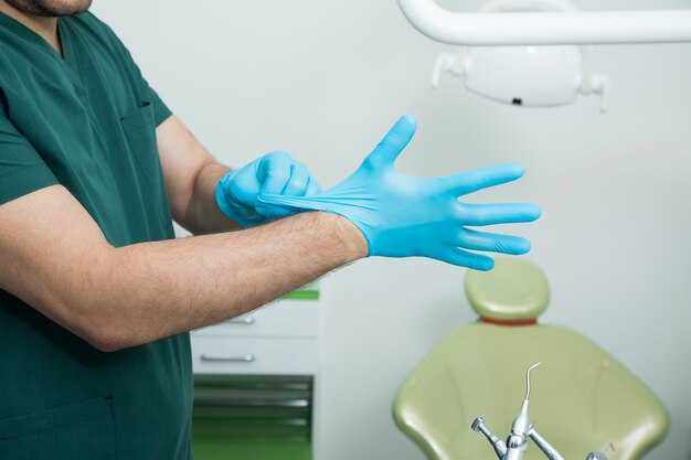 O dentista calça luvas antes do trabalho