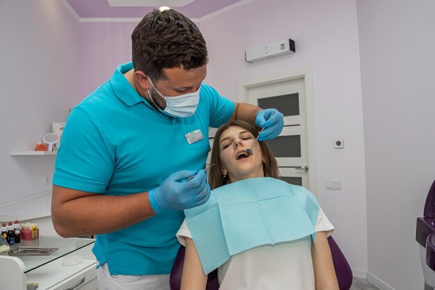 O dentista-chefe examina os dentes curados tratados em uma jovem