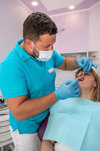 O dentista-chefe examina os dentes curados tratados em uma jovem