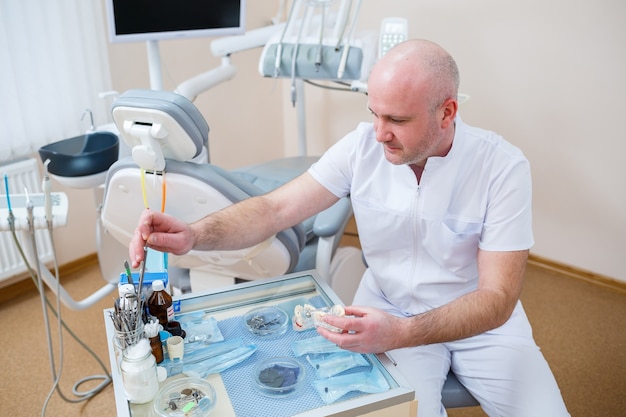 O dentista está sozinho no local de trabalho, o médico está no consultório dentário. Equipamento profissional para tratamento dentário