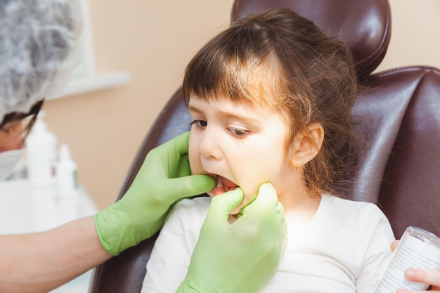 O dentista examina os dentes da criança no conceito de medicina e odontologia da cadeira odontológica