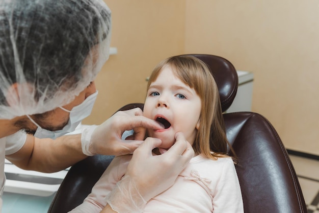 O dentista examina os dentes da criança no conceito de medicina e odontologia da cadeira odontológica