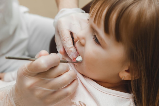 O dentista examina os dentes da criança no conceito de medicina e odontologia da cadeira odontológica