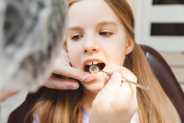 O dentista examina os dentes da criança no conceito de medicina e odontologia da cadeira odontológica