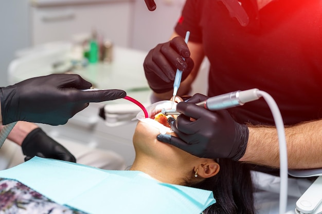 O dentista examina os dentes do paciente com um microscópio odontológico Equipamento médico moderno Conceito de tratamento oral Closeup Foco seletivo