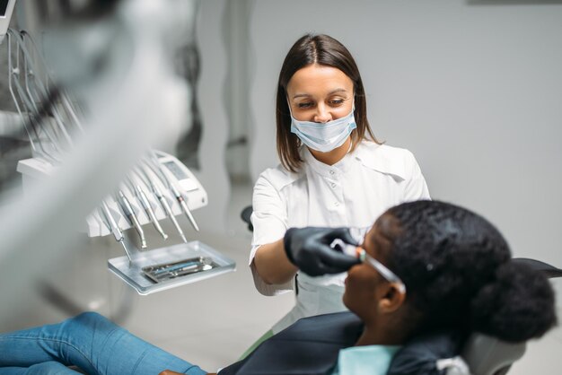 O dentista examina os dentes na clínica dentária.