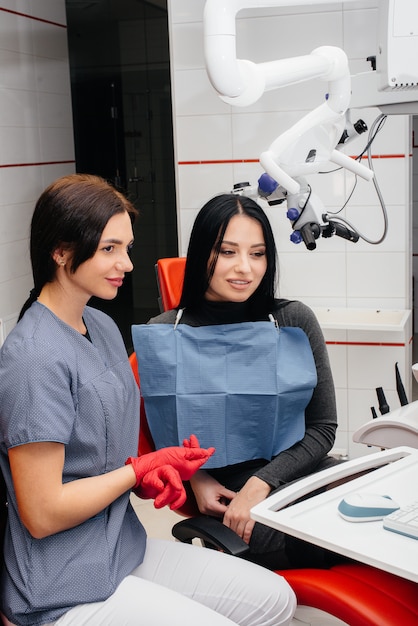 O dentista mostra uma imagem dos dentes do paciente e informa o tratamento necessário. odontologia, saúde.