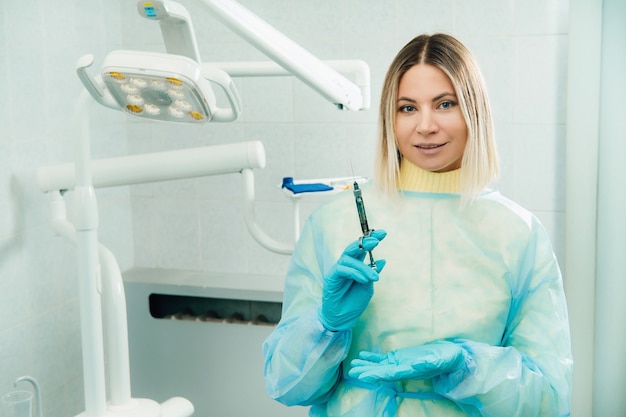 O dentista segura uma seringa de injeção para o paciente no consultório.