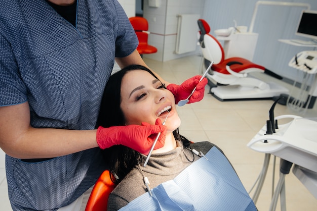 O dentista trata os dentes da garota no paciente. Odontologia