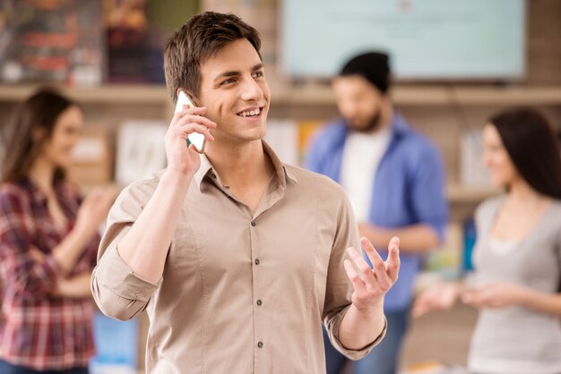 O designer de interiores vestiu a fala ocasional no telefone no escritório.