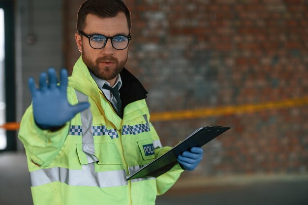 Foto o detective está a recolher provas numa cena de crime no local de construção.