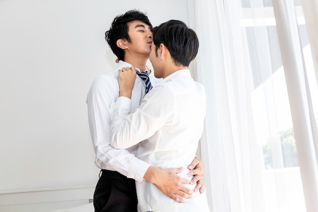 O doce momento do amor. casal homossexual asiático beijando o marido antes do trabalho