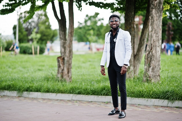 O doutor masculino afro-americano novo com um estetoscópio levantou ao ar livre.